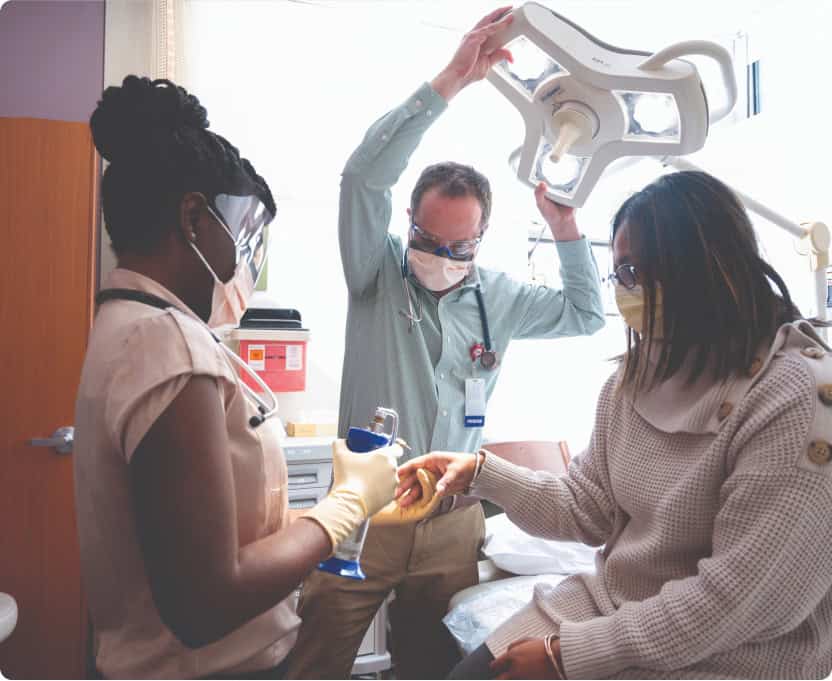 physician mentor supervises new resident performing patient procedure