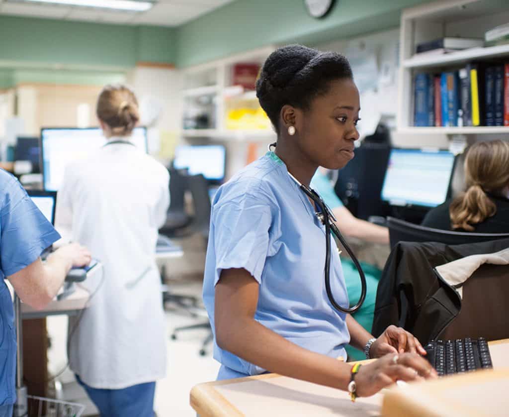 residents working on computers in nurses station